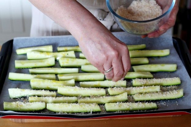 Die Zucchini-Parmesan-Mischung über die Fritten streuen