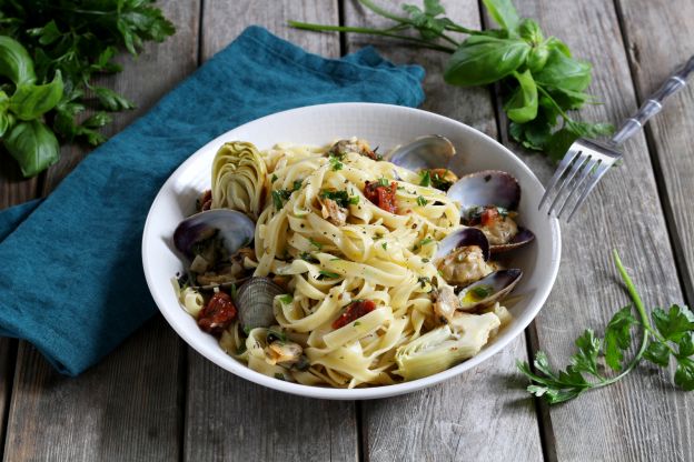 Tagliatelle in Venusmuschel-Weißweinsauce mit getrockneten Tomaten und Artischocken