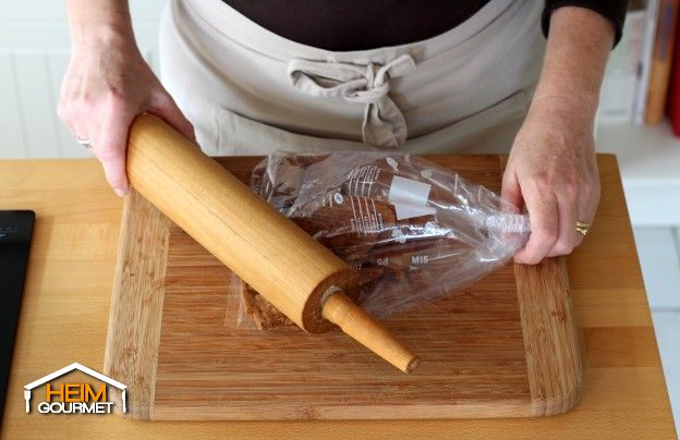 Die Kekse in einen Gefrierbeutel füllen und mit einer Küchenrolle zerkleinern.