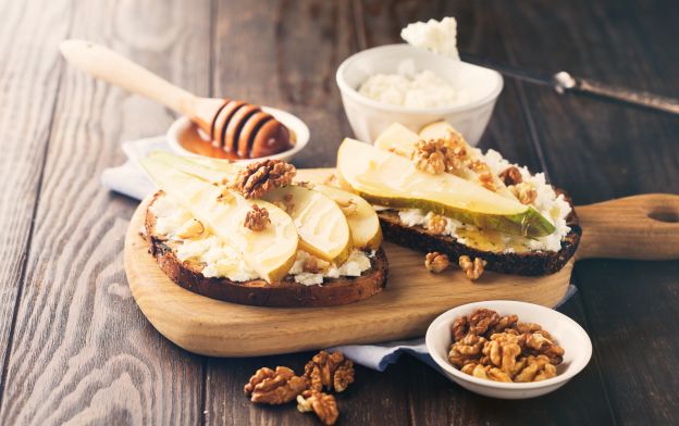 Brotscheiben mit Birne, Ziegenkäse, Nüssen und Honig