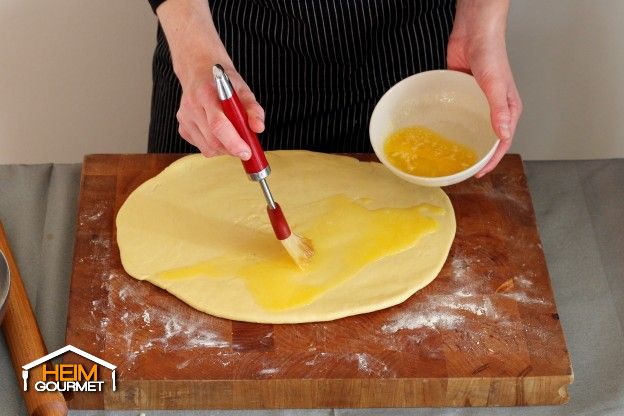 Den Teig mit der geschmolzenen Butter bestreichen.